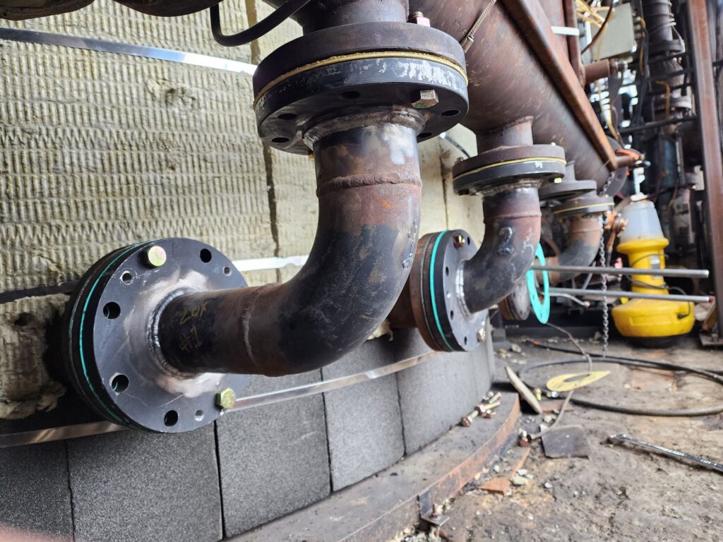 Flanged pipe elbow welded on industrial plant equipment