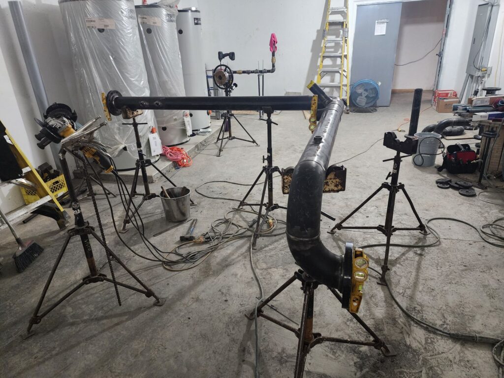 Welded pipe spools staged in a Calgary mechanical room