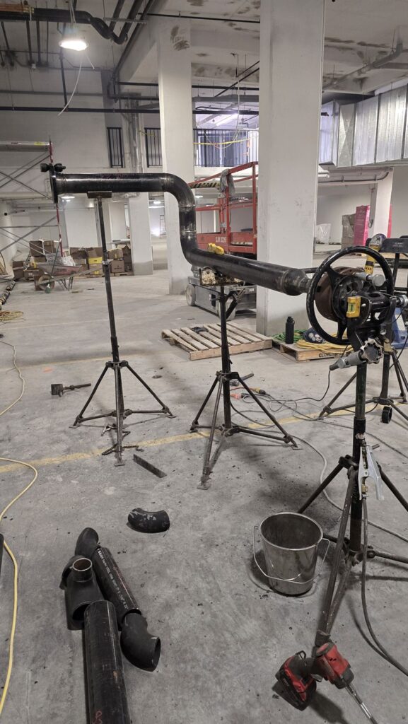Pipe spools fit up on stands in a parkade