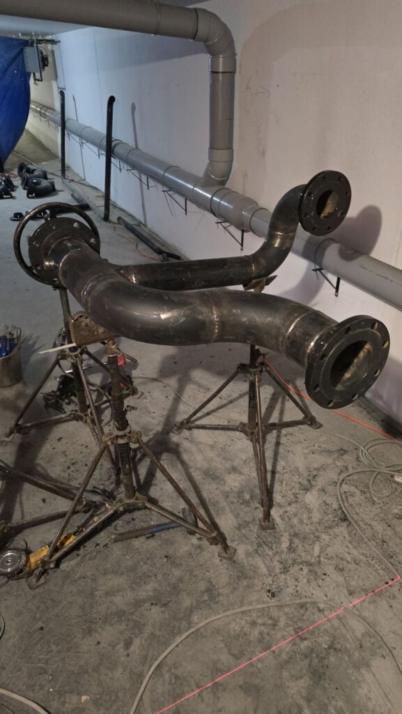 Welded pipe spool assembly on fabrication stands