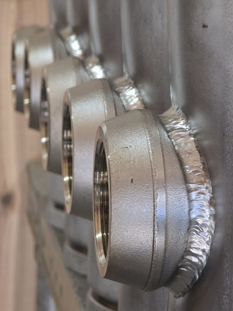 Stainless steel manifold with TIG welded threaded outlets